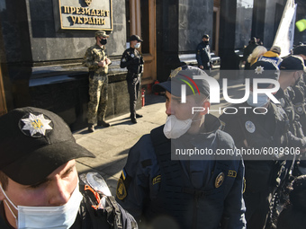 Policemen wearing protective masks as a preventive measure against the coronavirus COVID-19 stand guard outside the President Volodymyr Zele...