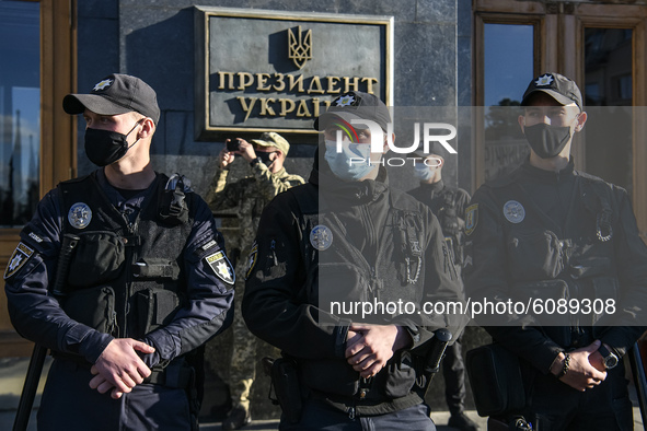 Policemen wearing protective masks as a preventive measure against the coronavirus COVID-19 stand guard outside the President Volodymyr Zele...