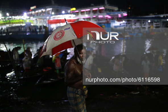 Boatmen wait for passenger along the Buriganga River on a rainy day in Dhaka, Bangladesh on October 23, 2020.  Rainfall occurs in various pa...