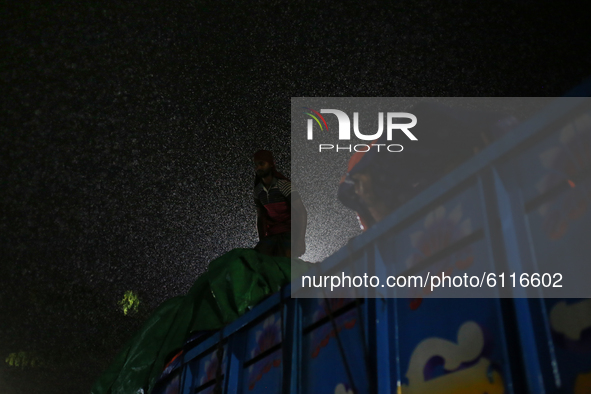 Labors cover polythene on a truck to protect goods during rainfall in Dhaka, Bangladesh on October 23, 2020.  Rainfall occurs in various par...