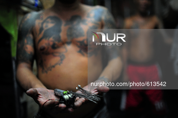 Go to http://nurphoto.com/reportages/ to see more - An inmate shows the tattoo maker that they are using, made of homemade materials such as...