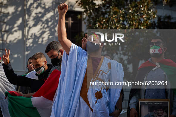 A man wearing face mask a djellaba raises his fist during a demonstration to demand the end of Morocco's occupation in Western Sahara, in su...