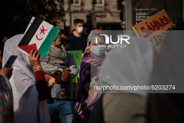 Women wearing face mask carrying a Saharan flag, placards and dressed in Malahfas during a demonstration to demand the end of Morocco's occu...