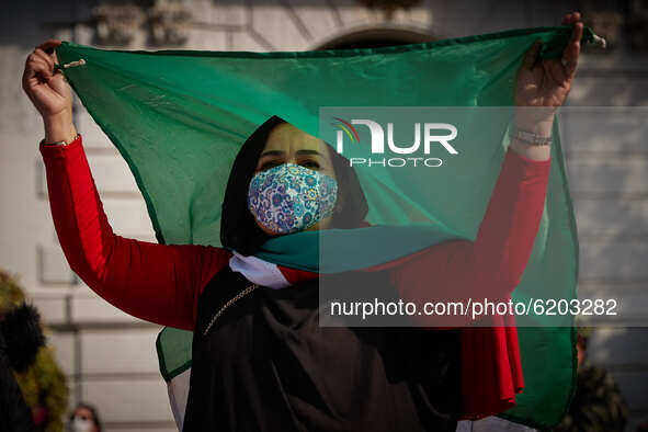A woman wearing face mask dances under a Sahara flag during a demonstration to demand the end of Morocco's occupation in Western Sahara, in...