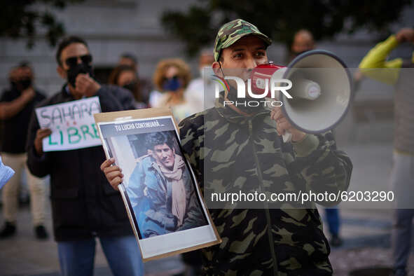 A man speaks through a megaphone and carries a photo during a demonstration to demand the end of Morocco's occupation in Western Sahara, in...