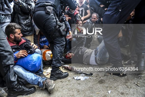 A migrant collapses while waiting to enter to the transfer camp in Opatovac near border crossing point between Serbia and Croatia. Opatovac,...