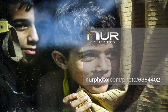 Migrant children are waiting in a bus to be transfered to the camp in Opatovac near border crossing point between Serbia and Croatia. Septem...