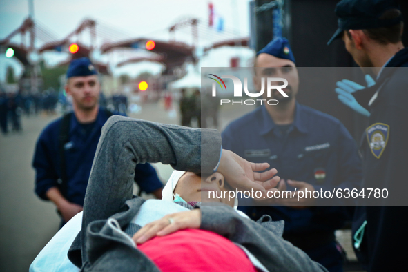 A pregnant refugee woman is being assisted while arriving at the Hungary-Croatia border point in Baranjsko Petrovo Selo, Croatia, on Septemb...