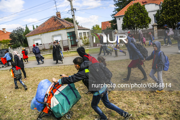 Refugees walk to the Hungarian-Austrian border between Hegyeshalom and Nickelsdorf, after they arrived by train to Hegyeshalom, Hungary on 2...