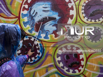 A man spray disinfectan to the mural. Mural Covid19 in Tangerang, Banten, Indonesia, on 26 January 2021. Indonesia reach out to 1 million of...