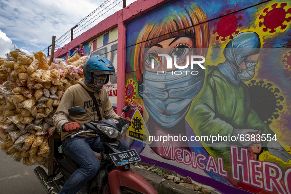 A man passing by the mural in Tangerang, Banten, Indonesia, 26 January 202. Indonesia reach out to 1 million of Covid19 positive case with t...