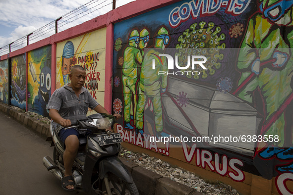 Tangerang, Banten, Indonesia, 26 January 2021 :An old man without mask passing by the mural.  Indonesia reach out to 1 million of Covid19 po...