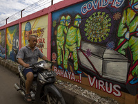 Tangerang, Banten, Indonesia, 26 January 2021 :An old man without mask passing by the mural.  Indonesia reach out to 1 million of Covid19 po...
