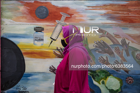 A woman passing by the mural Covid19 in Tangerang, Banten, Indonesia, on 26 January 2021. Indonesia reach out to 1 million of Covid19 positi...