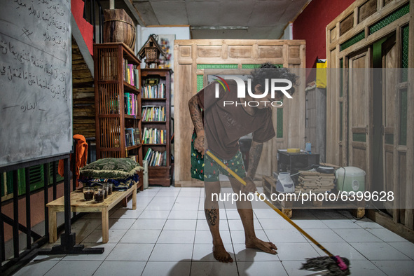 A Member of the boarding school cleaning the floor with tattoos al over his body. Islamic boarding school for punk and street children in Ru...