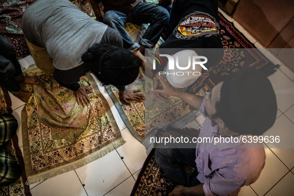 Students kissing the hand of Ustadz HALIM AMBIYA after finished praying. Islamic boarding school for punk and street children in Ruko Cimang...