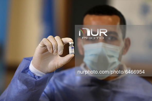 A Palestinian health worker displays a vial of Russia's Sputnik V vaccine as he prepares to vaccinate Matthias Schmale, UNRWA's Gaza directo...