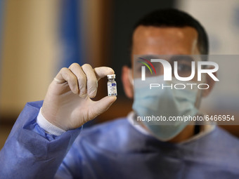 A Palestinian health worker displays a vial of Russia's Sputnik V vaccine as he prepares to vaccinate Matthias Schmale, UNRWA's Gaza directo...