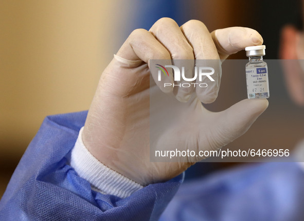 A Palestinian health worker displays a vial of Russia's Sputnik V vaccine as he prepares to vaccinate Matthias Schmale, UNRWA's Gaza directo...