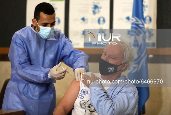 Matthias Schmale, UNRWA's Gaza director, receives a vaccine against the coronavirus disease (COVID-19) at a United Nations-run clinic in Gaz...