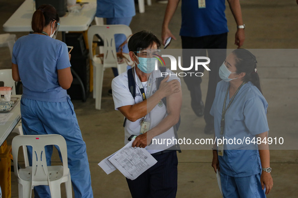 A healthcare worker greets a fellow hospital worker after getting inoculated with the Sinovac COVID19 vaccine during a ceremonial vaccinatio...