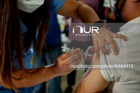 A nurse administers the Sinovac COVID19 vaccine during a ceremonial vaccination program held inside a sports stadium in Marikina City, east...