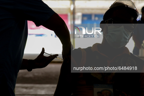 A nurse administers the Sinovac COVID19 vaccine during a ceremonial vaccination program held inside a sports stadium in Marikina City, east...