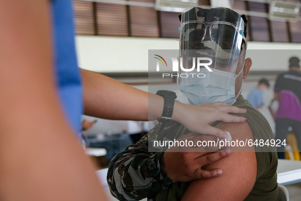 A member of the Philippine Navy gets inoculated with the Sinovac COVID19 vaccine during a ceremonial vaccination program held inside a sport...