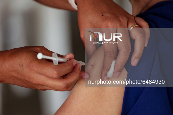 A nurse administers the Sinovac COVID19 vaccine during a ceremonial vaccination program held inside a sports stadium in Marikina City, east...