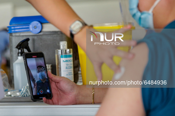 A nurse administers the Sinovac COVID19 vaccine during a ceremonial vaccination program held inside a sports stadium in Marikina City, east...