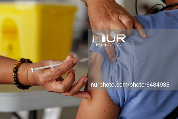 A nurse administers the Sinovac COVID19 vaccine during a ceremonial vaccination program held inside a sports stadium in Marikina City, east...