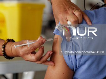 A nurse administers the Sinovac COVID19 vaccine during a ceremonial vaccination program held inside a sports stadium in Marikina City, east...