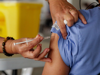 A nurse administers the Sinovac COVID19 vaccine during a ceremonial vaccination program held inside a sports stadium in Marikina City, east...