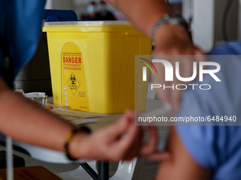 A nurse administers the Sinovac COVID19 vaccine during a ceremonial vaccination program held inside a sports stadium in Marikina City, east...