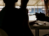 A nurse administers the Sinovac COVID19 vaccine during a ceremonial vaccination program held inside a sports stadium in Marikina City, east...