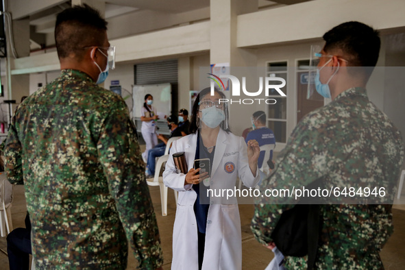 A doctor discusses the side-effects of the Sinovac COVID19 vaccine to military personnel during a ceremonial vaccination program held inside...