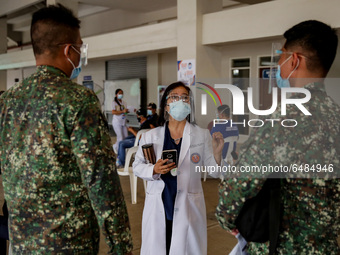 A doctor discusses the side-effects of the Sinovac COVID19 vaccine to military personnel during a ceremonial vaccination program held inside...