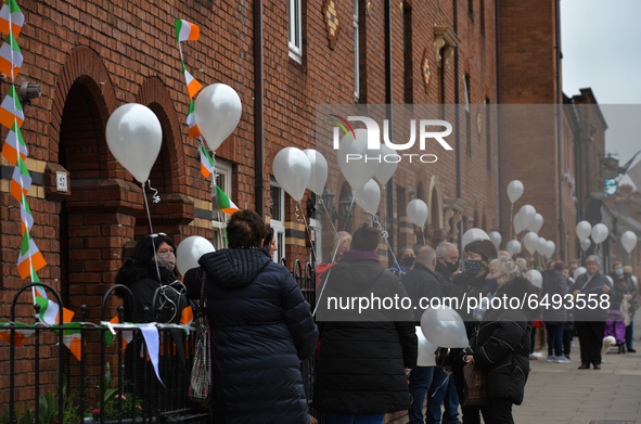 Residents of New Street in Dublin hold white balloons to say goodbye to their recently departed neighbour, Mrs. Quinn (age 89). Their homes...