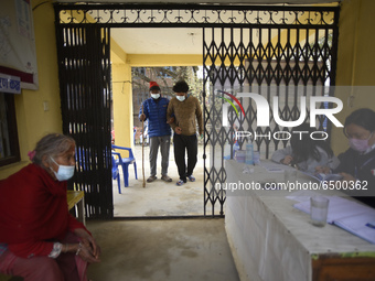 A family member helps to bring Nepalese People above 65 to get first dose of COVID19 vaccines developed by Oxford- AstraZeneca Plc at Bal Ku...