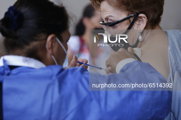 A person receives a dose of Pfizer-BioNTech Covid-19 vaccine before inject to an elderly, during mass vaccine inside of Hermanos Lopez Rayon...