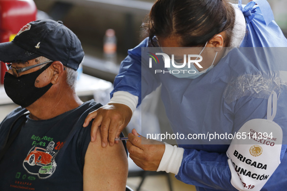 A person receives a dose of Pfizer-BioNTech Covid-19 vaccine before inject to an elderly, during mass vaccine inside of Hermanos Lopez Rayon...