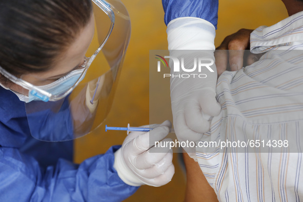 A person receives a dose of Pfizer-BioNTech Covid-19 vaccine before inject to an elderly, during mass vaccine inside of Hermanos Lopez Rayon...