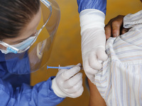 A person receives a dose of Pfizer-BioNTech Covid-19 vaccine before inject to an elderly, during mass vaccine inside of Hermanos Lopez Rayon...