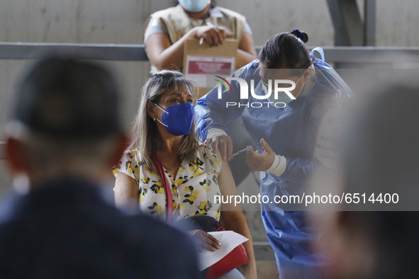 A person receives a dose of Pfizer-BioNTech Covid-19 vaccine before inject to an elderly, during mass vaccine inside of Hermanos Lopez Rayon...