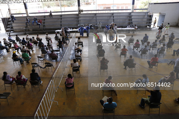 Persons wait  receive  a dose of Pfizer-BioNTech Covid-19 vaccine   during mass vaccine inside of Hermanos Lopez Rayon sports center, a desi...