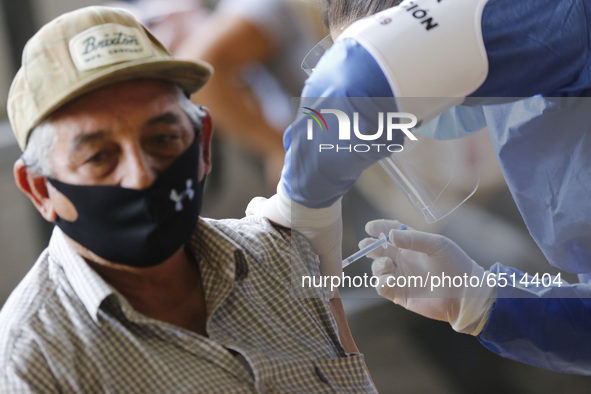 A person receives a dose of Pfizer-BioNTech Covid-19 vaccine before inject to an elderly, during mass vaccine inside of Hermanos Lopez Rayon...