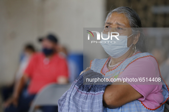 Persons wait  receive  a dose of Pfizer-BioNTech Covid-19 vaccine   during mass vaccine inside of Hermanos Lopez Rayon sports center, a desi...