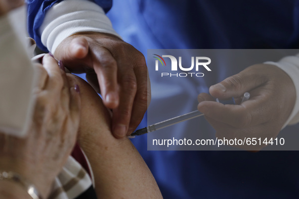 A person receives a dose of Pfizer-BioNTech Covid-19 vaccine before inject to an elderly, during mass vaccine inside of Hermanos Lopez Rayon...