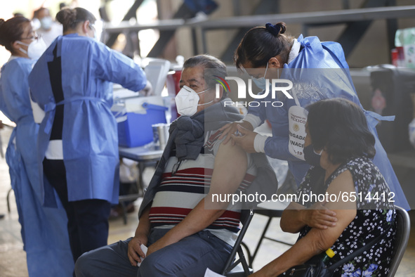 A person receives a dose of Pfizer-BioNTech Covid-19 vaccine before inject to an elderly, during mass vaccine inside of Hermanos Lopez Rayon...