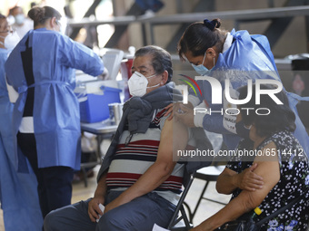 A person receives a dose of Pfizer-BioNTech Covid-19 vaccine before inject to an elderly, during mass vaccine inside of Hermanos Lopez Rayon...